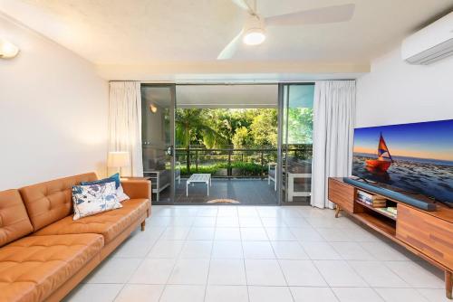 a living room with a couch and a flat screen tv at Azure Beach Retreat 2 in Rainbow Beach