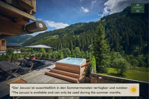 a hot tub on a deck with a mountain at Chalet Tannenbaum in Saalbach-Hinterglemm
