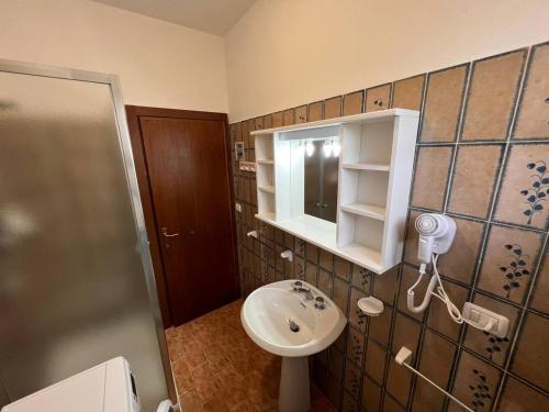 a bathroom with a sink and a mirror and a shower at Residence Delfini in Principina a Mare