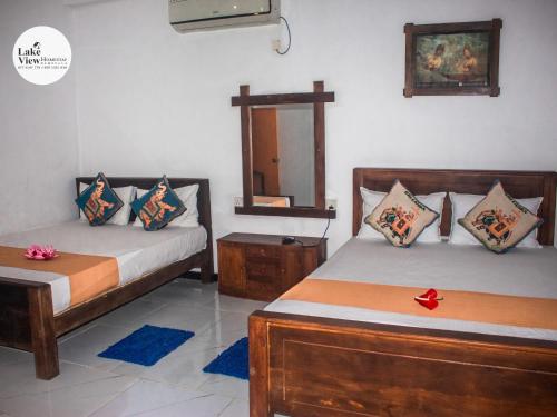 a bedroom with two beds and a mirror at Lake View Dambulla in Dambulla