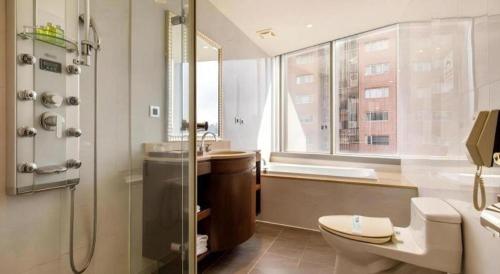 a bathroom with a shower and a toilet and a sink at Hotel HD Palace in Taipei
