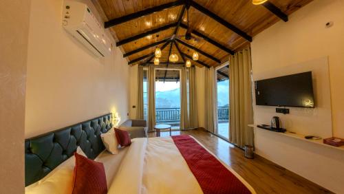 a bedroom with a large bed and a television at Cliffs & Clouds in Bhīm Tāl
