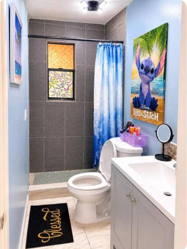 a bathroom with a toilet and a painting of a bunny at Perfect Family Group Getaway in West Palm Beach