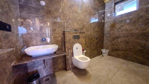 a bathroom with a toilet and a sink at Cliffs & Clouds in Bhīm Tāl