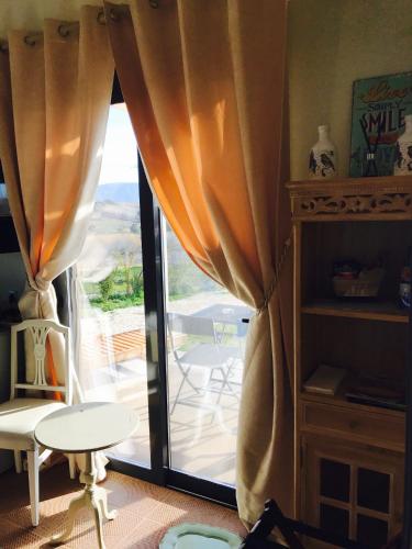 a room with a window with curtains and a table at Villa Vravrona Tower & Suites in Markopoulo