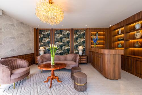 a living room with a table and chairs and a chandelier at Kaysorn Siri in Ban Kham Kom