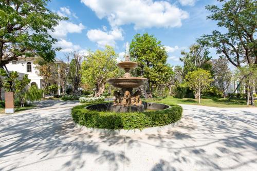 a fountain in the middle of a driveway at Kaysorn Siri in Ban Kham Kom