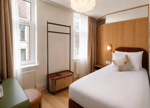 a hotel room with a bed and a mirror at De Herbert Amsterdam - Formerly France Hotel in Amsterdam