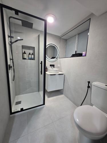 a bathroom with a shower and a toilet and a sink at Ers's on Tamar B&B in Riverside