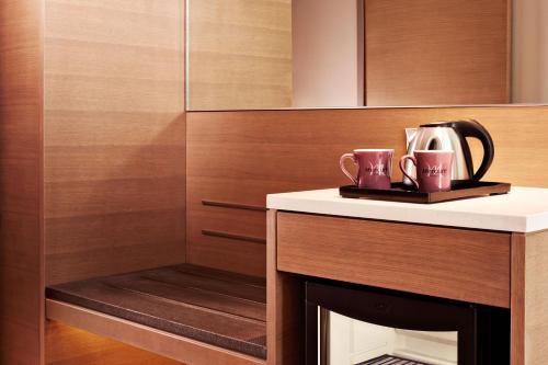 a fireplace with two mugs on top of it at Mercure Kuala Lumpur Shaw Parade in Kuala Lumpur
