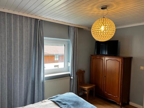 a bedroom with a bed and a chandelier and a window at Privathaus Sieglinde in Sondermoning