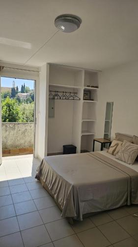 a bedroom with a large bed and a large window at Studios Corte Restonica in Corte