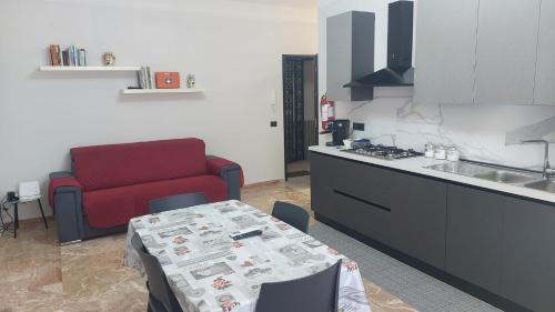 a kitchen with a red couch and a table in a kitchen at A Casa di Nonna Lidia in Crotone