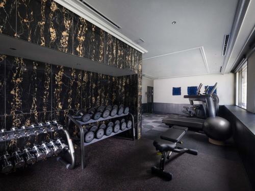 a fitness room with a gym with weights and a treadmill at Mercure Tokyo Hibiya in Tokyo