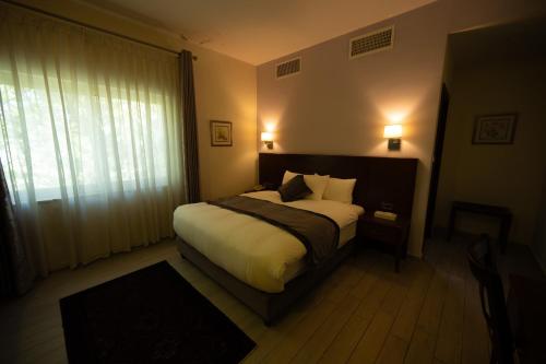 a bedroom with a large bed and a window at Lavender Boutique Hotel in Ramallah