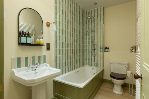 a bathroom with a sink and a tub and a toilet at The Lodge at Dabton House in Carronbridge