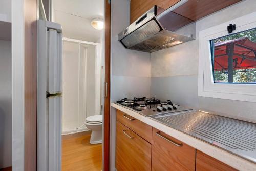 a small kitchen with a stove and a window at Camping La Chiocciola a Capannole in Capannole