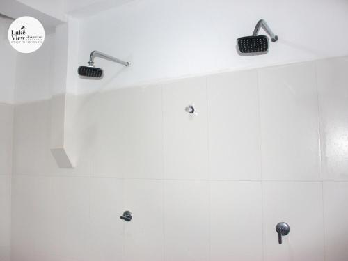 a bathroom with white walls and white tiles at Lake View Dambulla in Dambulla
