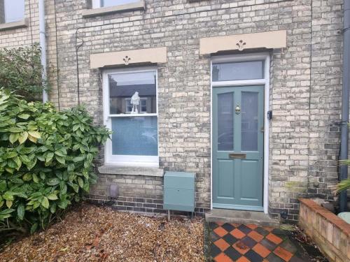 a brick house with a blue door and a window at Central Cambridge -comfortable Victorian Terrace in Cambridge