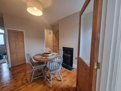 a dining room with a table and chairs and a fireplace at Central Cambridge -comfortable Victorian Terrace in Cambridge
