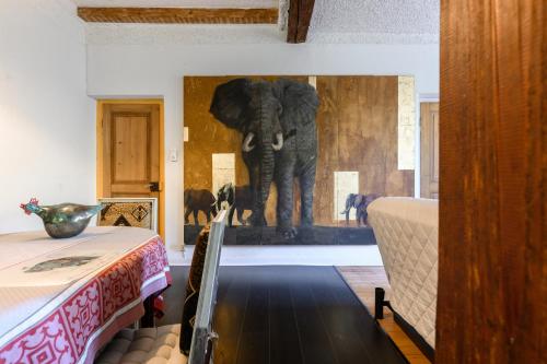 a bedroom with an elephant painting on the wall at Appartement Cadichon in Munster