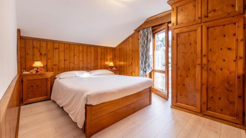a bedroom with a large bed and a window at Casa Amabile in Cortina dʼAmpezzo