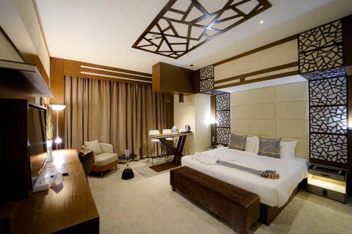 a hotel room with a large bed and a desk at Ras Al Khaimah Hotel in Ras al Khaimah