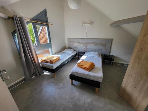 a bedroom with two beds and a window at Camping Le Païsserou in Najac