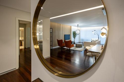 a mirror reflecting a living room and a dining room at Funchal Next Corner Plaza in Funchal