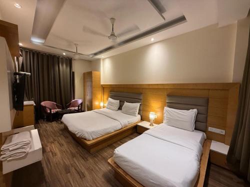 a hotel room with two beds and a chair at my divine hotel in Amritsar