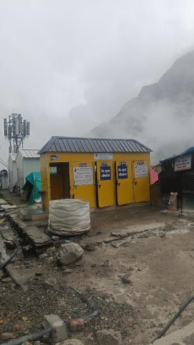a yellow building with signs on the side of it at Kedar cloud camp in Kedārnāth