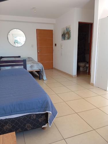 a bedroom with two beds and a tile floor at El Depto de Roberto in Villa María