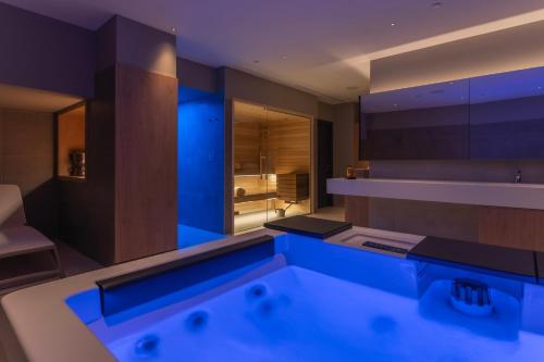a bathroom with a bath tub with blue lighting at Monumenti Heritage Hotel&Resort in Pula