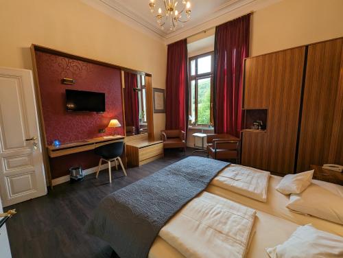 a hotel room with a large bed and a desk at Weinhotel St. Stephanus in Zeltingen-Rachtig