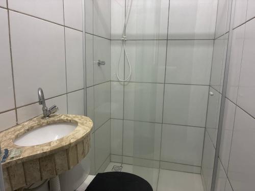 a bathroom with a sink and a shower at Hospedagem da Néli 2 in Aparecida