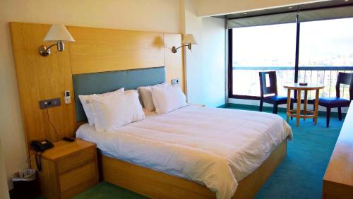 a hotel room with a large bed and a table at Oakland Hotel in Rayfūn