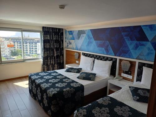 a hotel room with two beds and a large window at Diamond Hill Resort Hotel in Alanya