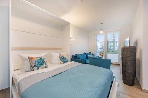 a bedroom with a blue bed and a couch at FeWo Tommy in Zirchow
