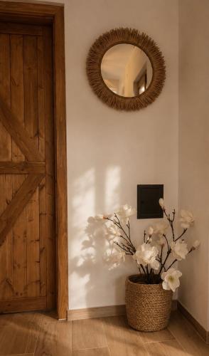 a room with a mirror and a vase with white flowers at Między łąką a lasem in Żdżar