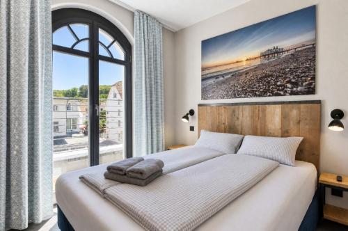 a bedroom with a bed and a large window at Ferienwohnung Sandbank in der Villa Martha Binz in Binz