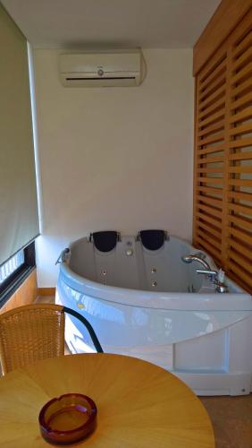a bath tub in a room with a wooden table at Oakland Hotel in Rayfūn