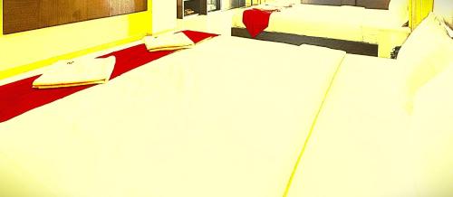 a white bed in a room with two beds at The B And D Hotel in Guwahati