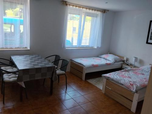 a room with two beds and a table and chairs at Apartmán in Doubravice