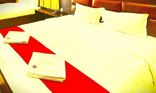 a red and white bed with two towels on it at The B And D Hotel in Guwahati