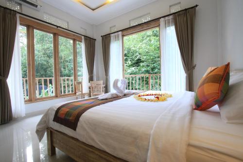 una camera da letto con un grande letto e finestre di Gading Homestay Ubud ad Ubud