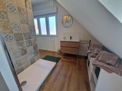 a attic bathroom with a shower and a sink at La maison des Hirondelles 2 in Fort-Mahon-Plage