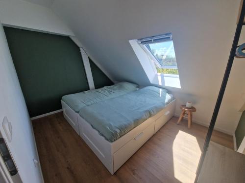 a small bedroom with a bed in a attic at La maison des Hirondelles 2 in Fort-Mahon-Plage