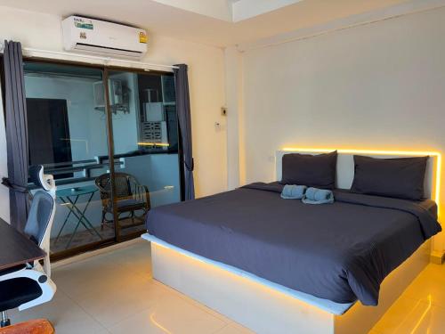 a bedroom with a large bed and a balcony at Lagoon vibes in Pattaya