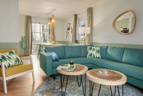 a living room with a blue couch and a table at Center Parcs Eifel Mosel Nürburgring in Gunderath