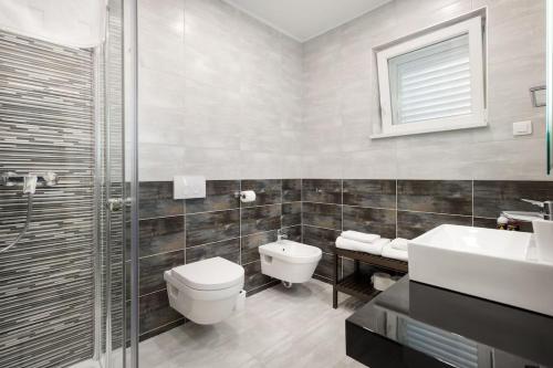 a bathroom with a toilet and a sink and a shower at Modern Penthouse Split with Jacuzzi & Terrace in Split
